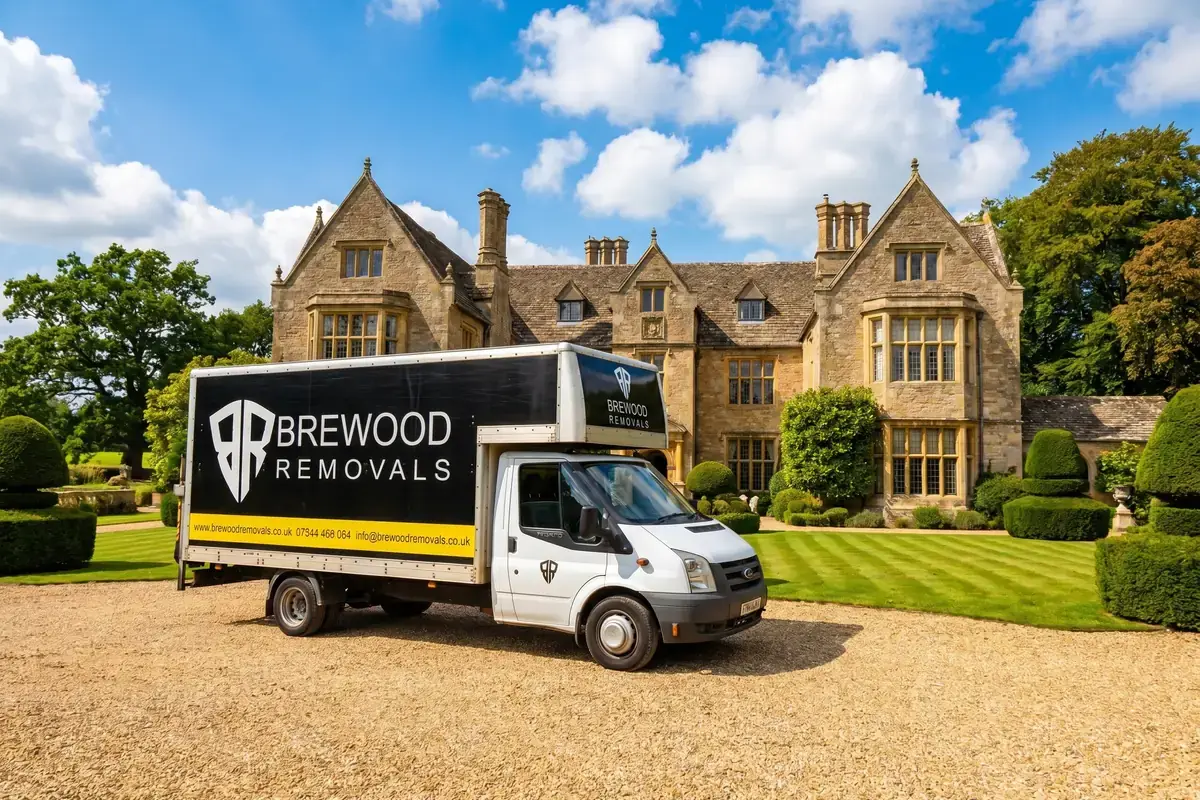 A branded Brewood Removals van outside a grand West Midlands manor house on a sunny day